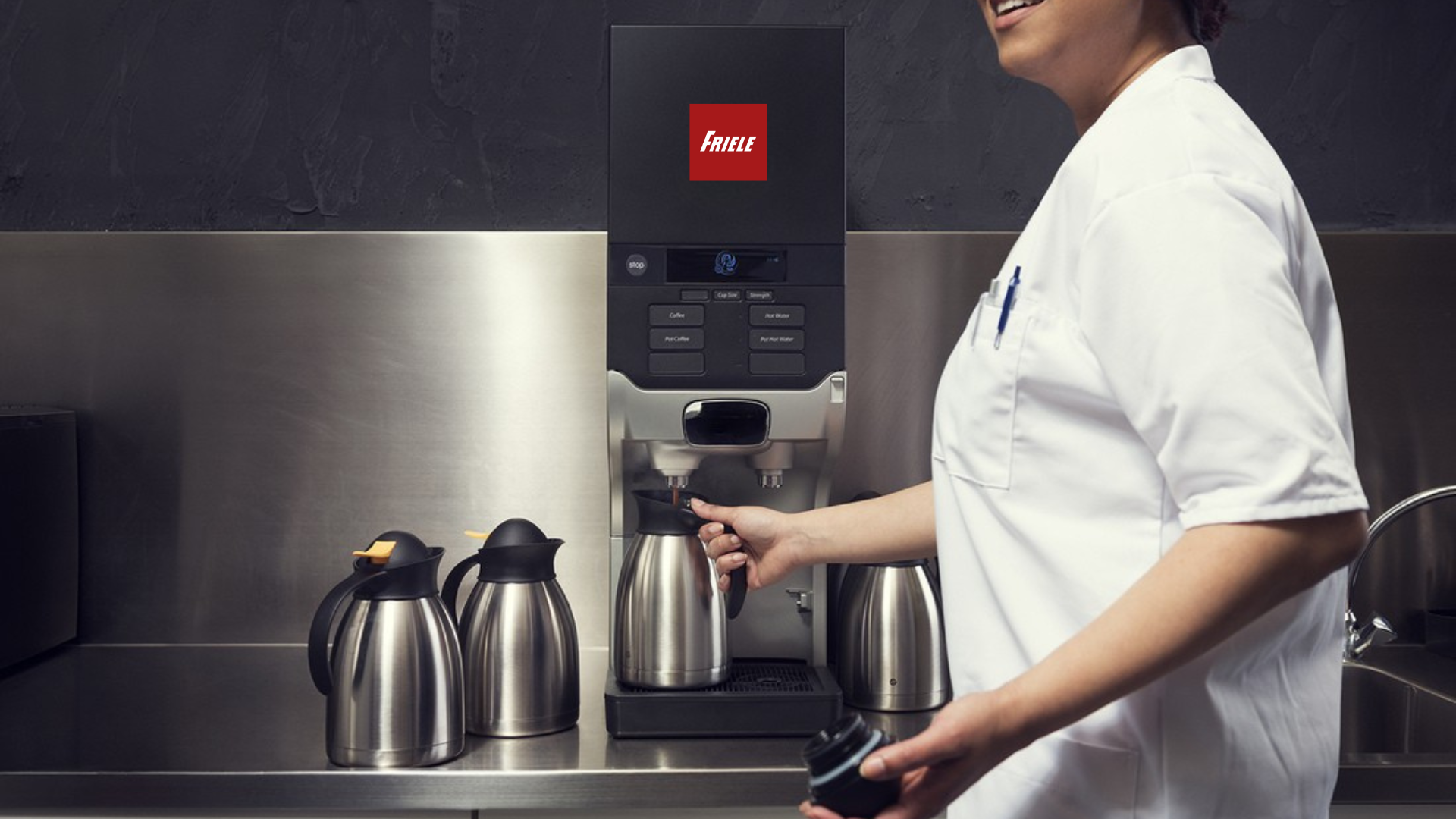 En kvinne tar kaffe fra kaffemaskinen