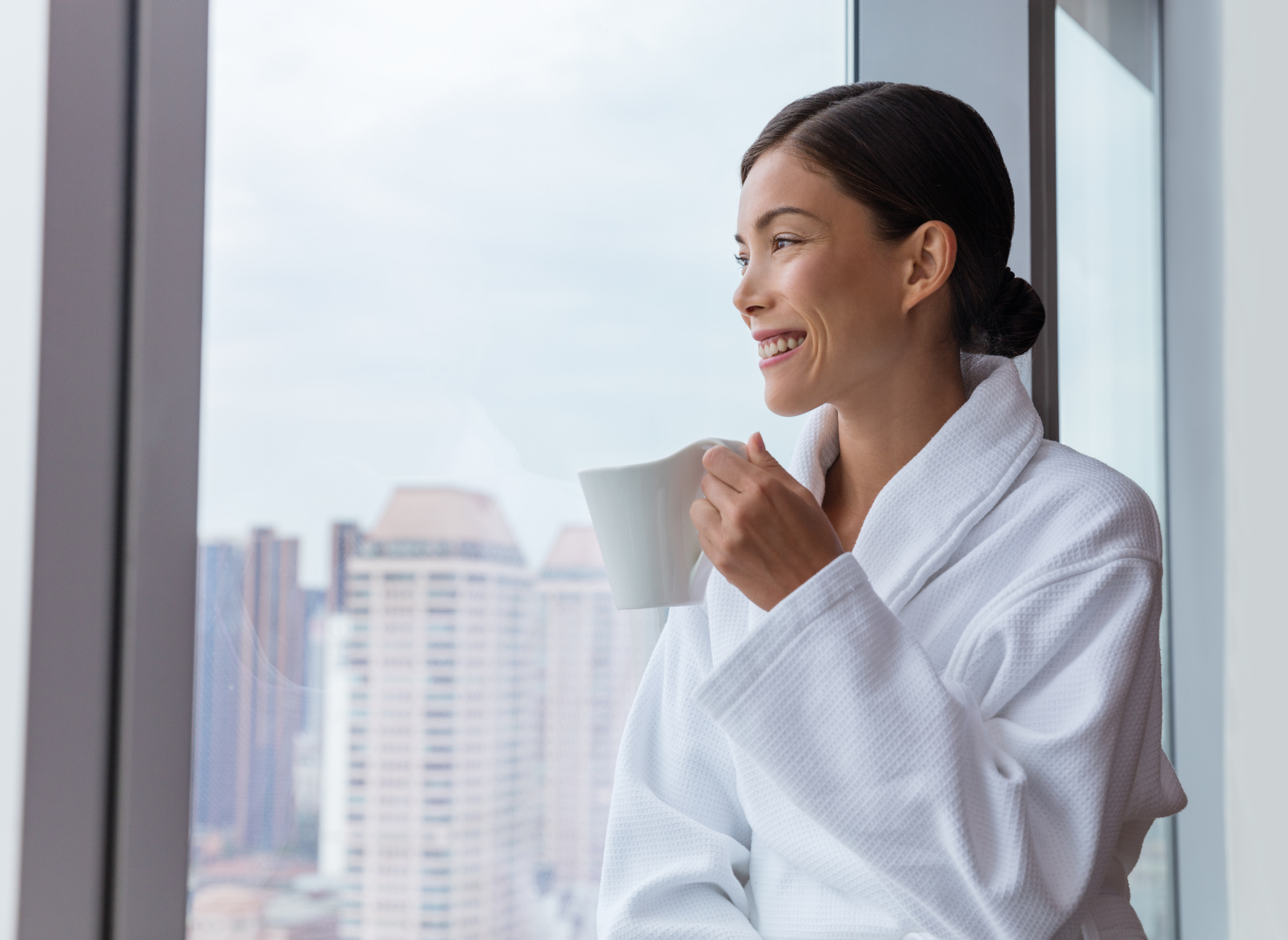 woman sitting in hotel room drinking coffee